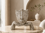 Quiet Reflection mosaic face resting on hands sculpture styled on a marble table