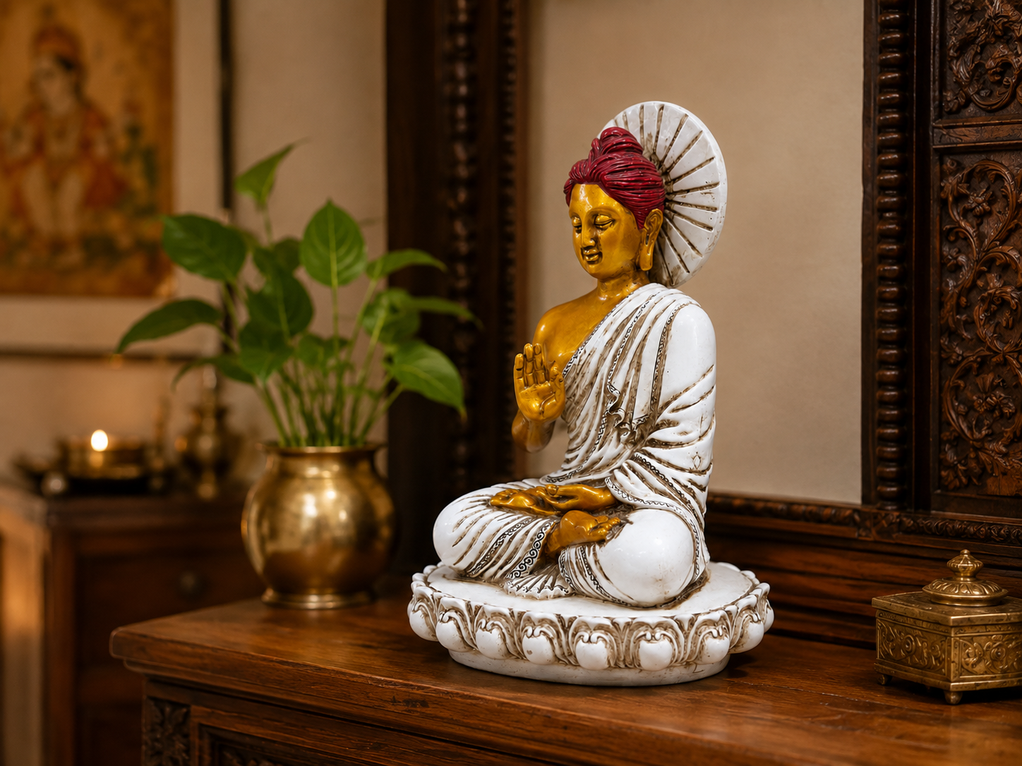 White, gold and red Buddha statue displayed on a wooden console
