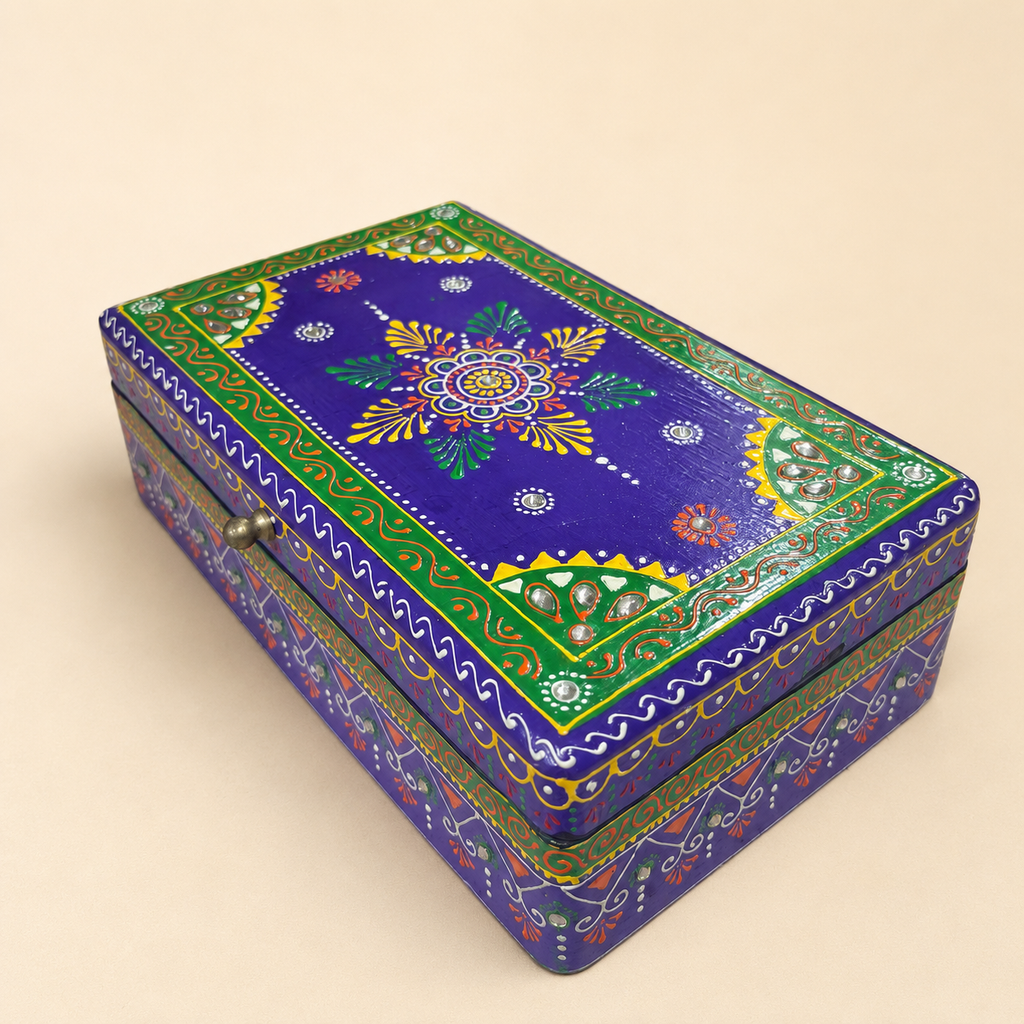 Angled view of the purple keepsake box showing its floral lid, green borders and mirrorwork details
