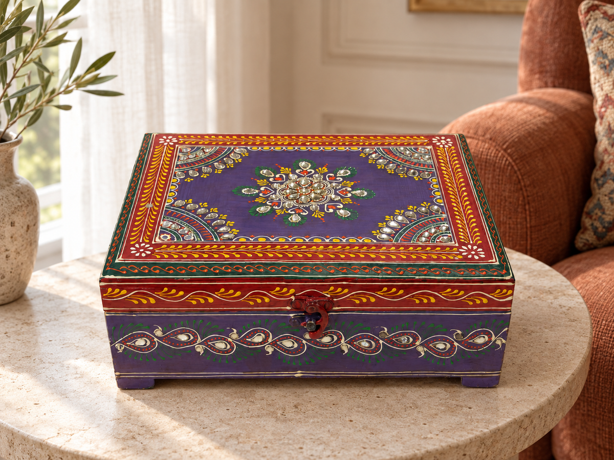 Rang Raas purple mirrorwork chest displayed on a round stone table in a sunlit reading nook