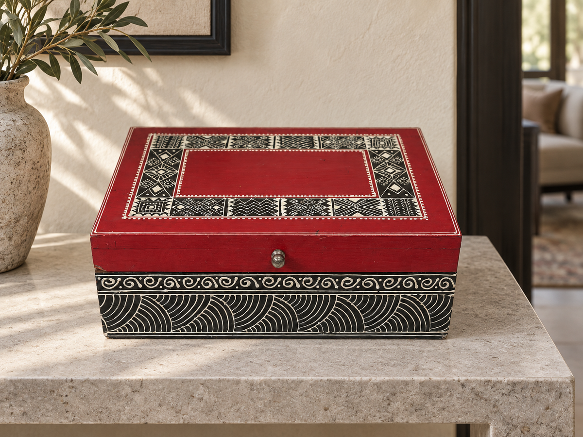 Red and black Rang Rekha keepsake box displayed on a limestone console