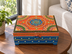 Rang Tarang orange and blue keepsake chest displayed on a round table beside a garden window