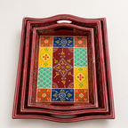 Top view of three red nested trays with colourful floral and geometric patterns