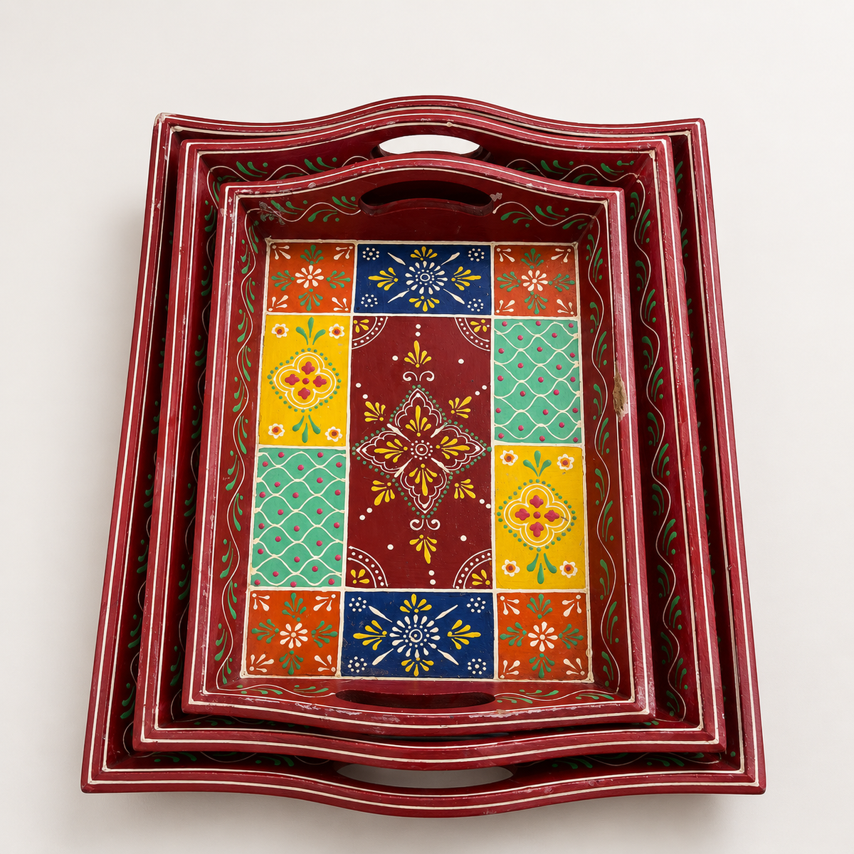 Top view of three red nested trays with colourful floral and geometric patterns