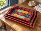 Multicolour floral nested tray set on a wooden table beside a blue shutter