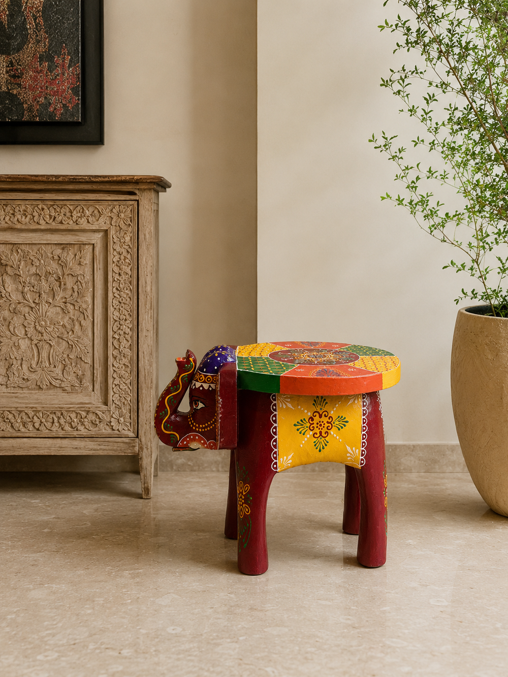 Colourful elephant-shaped mini decorative stool beside a carved cabinet