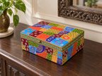 Decorative patchwork storage box on a wooden console beneath a carved mirror