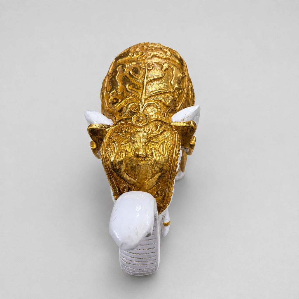 Ornate gold relief detailing on the ivory elephant sculpture viewed from the front