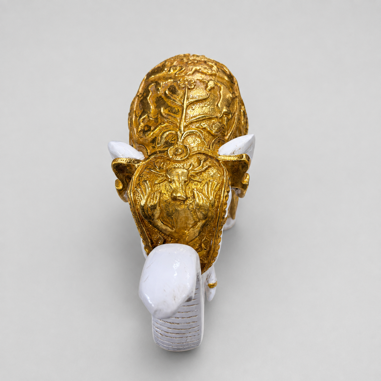 Ornate gold relief detailing on the ivory elephant sculpture viewed from the front