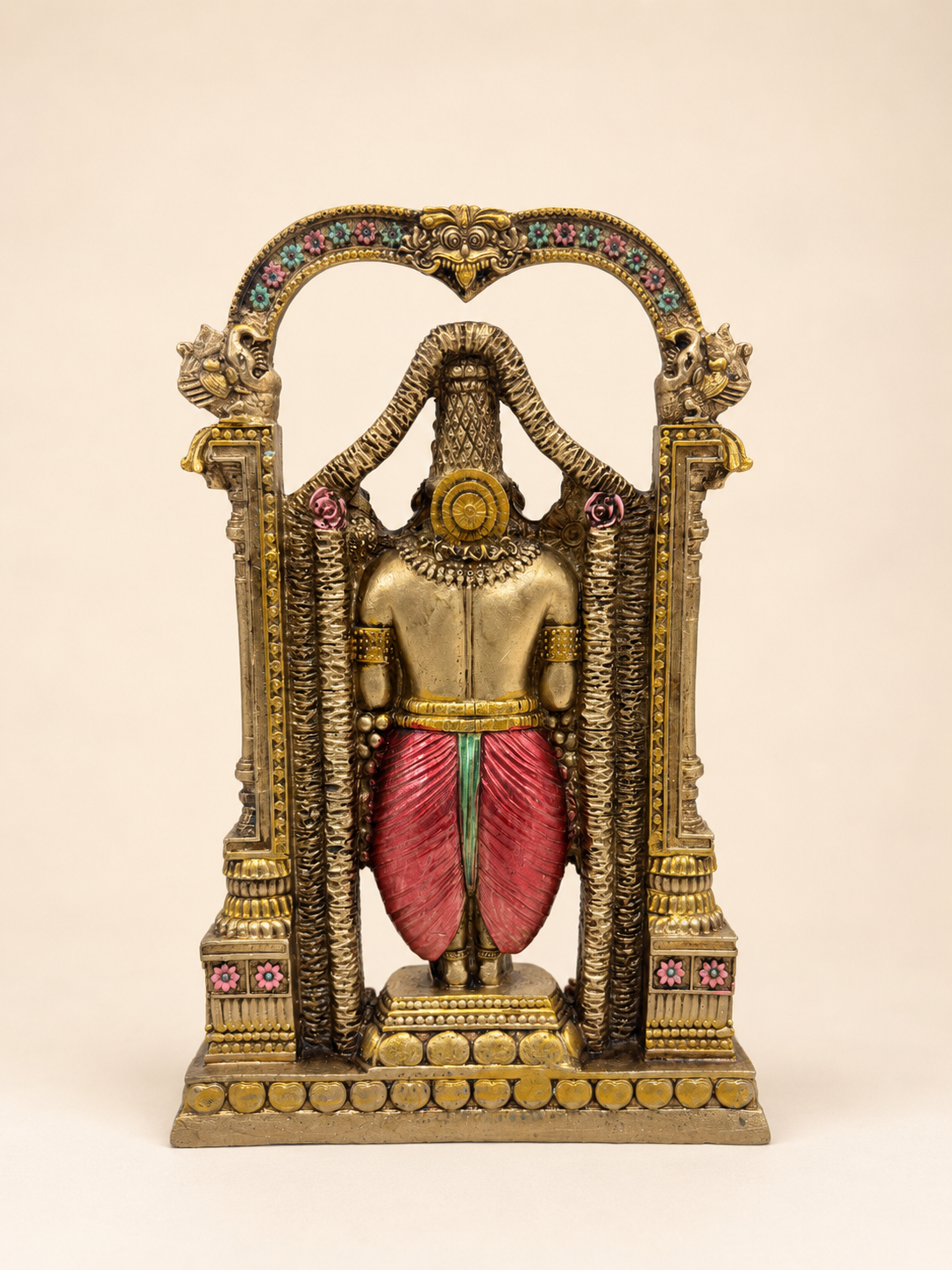 Rear view of the Tirupati Balaji idol showing the red garment and the floral arch