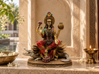 Ganga Maa idol on a home altar with lotus details, flowers and a lamp