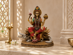 Ganga Maa idol on a sunlit altar beside a tall lamp and white flowers