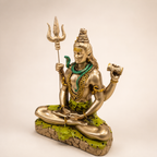 Angled view of the meditating Shiva idol showing the trishul, damru, green serpent and textured pedestal