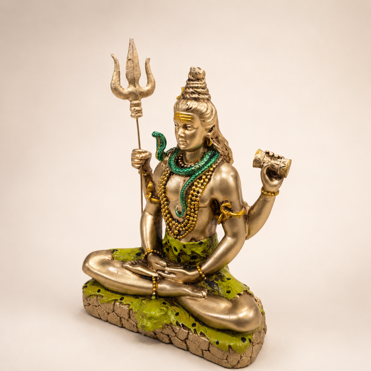 Angled view of the meditating Shiva idol showing the trishul, damru, green serpent and textured pedestal
