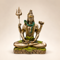 Meditating Shiva idol holding a trishul and damru, with a green serpent and gold-tone finish, front view