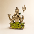 Rear view of the seated Shiva idol showing flowing hair, trishul, damru and green patterned drapery