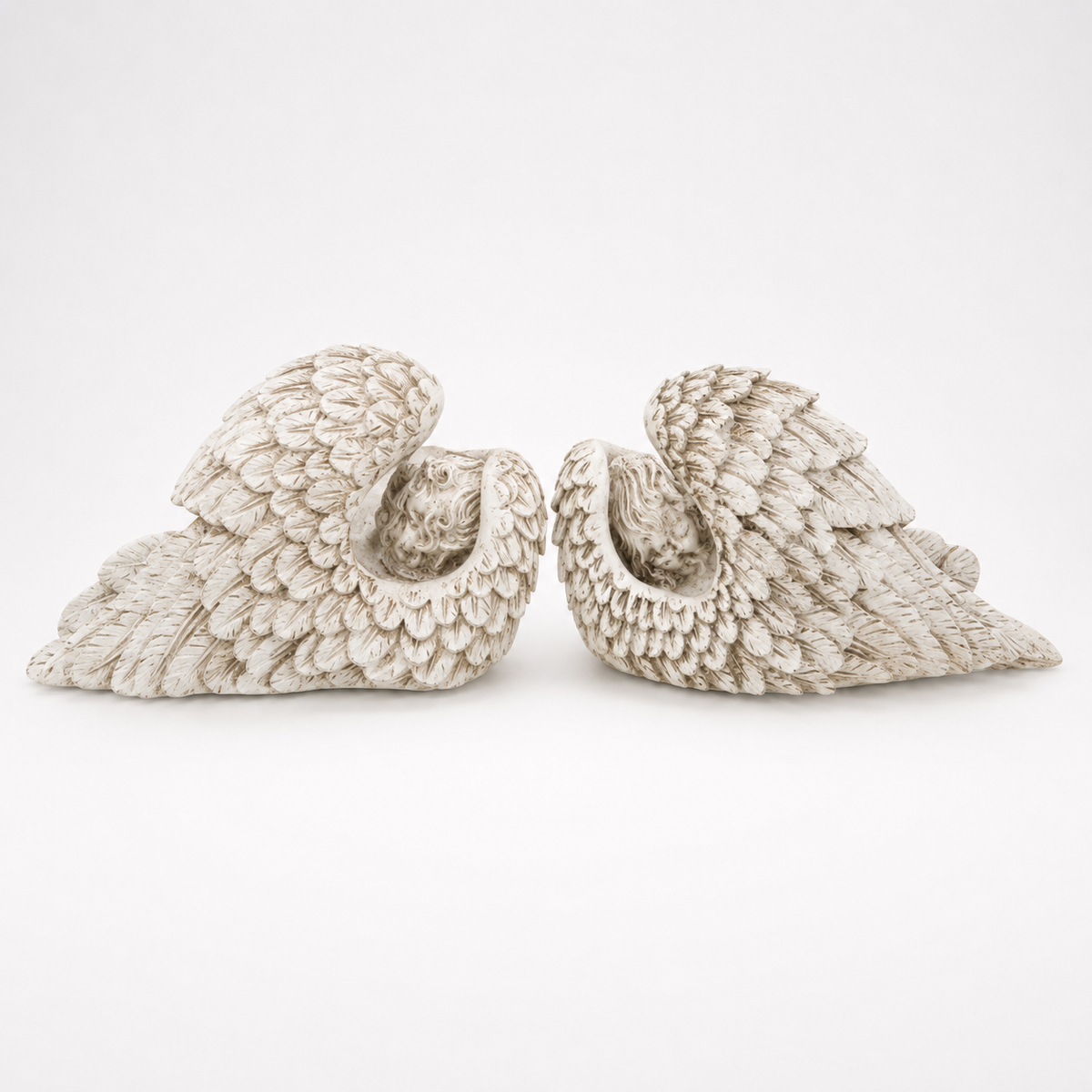 Pair of antique ivory sleeping angel wing sculptures, feathered reverse view