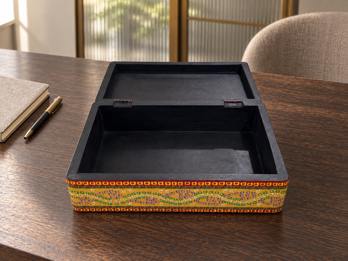 Open Surya Mandala keepsake box on a wooden desk, showing the black interior