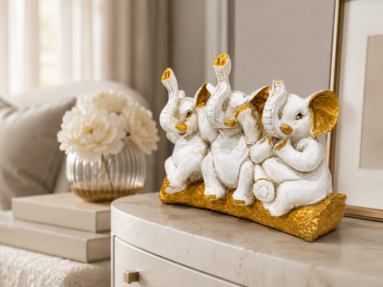 Three Wise Elephants ivory and gold sculpture styled on a sideboard