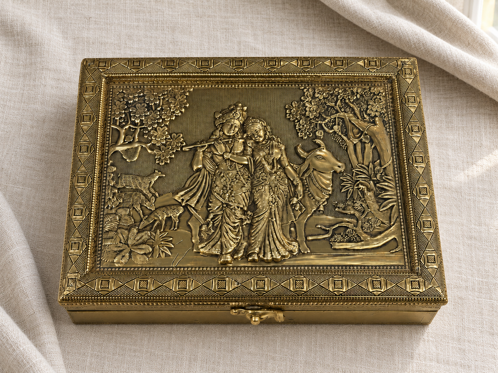 Gold-tone Radha Krishna jewellery box with decorative geometric borders on ivory linen