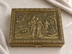 Gold-tone Radha Krishna jewellery box with decorative geometric borders on ivory linen